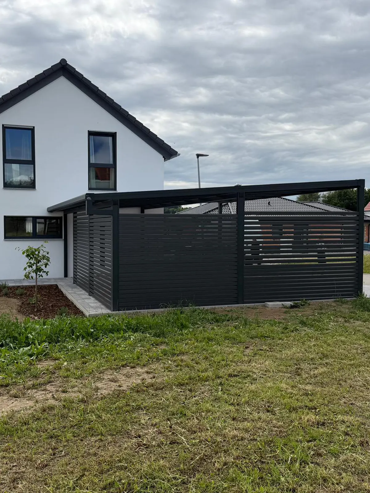 Carport in Kammeltal mit Seitenwand, Glas und Aluminium für EinfamilienhausCarport in Kamenthal mit Seitenwand, Glas und Aluminium für Einfamilienhaus