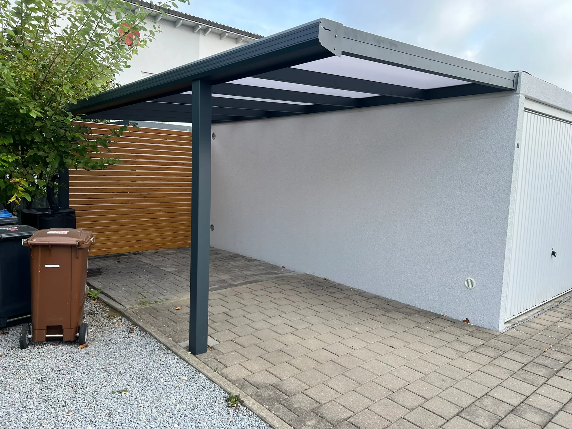 Carport mit Wandanschluss aus Aluminium in Gersthofen mit Polycarbonat-Dach und Seitenwand in Holzoptik